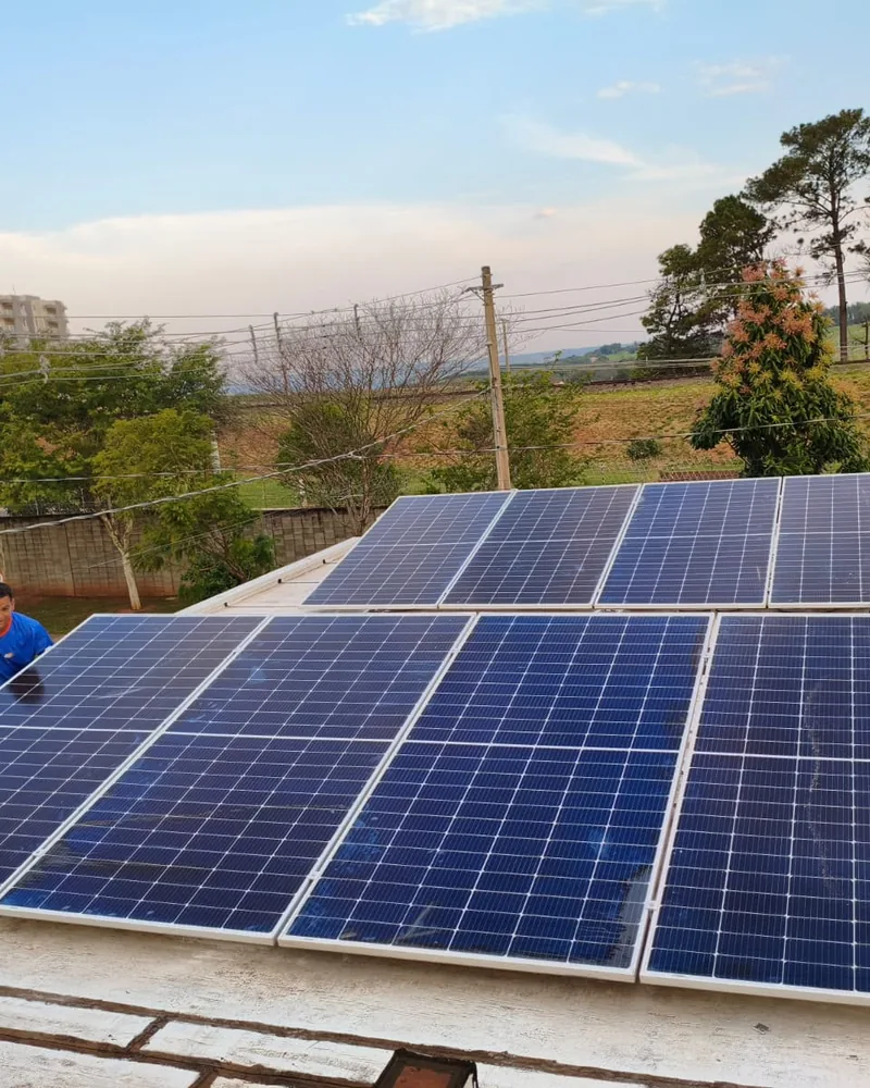 Instalação de painéis solares em cobertura, com equipe técnica trabalhando