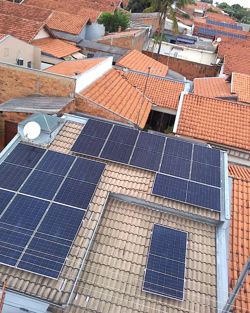 Vista aérea de telhados residenciais com painéis solares instalados