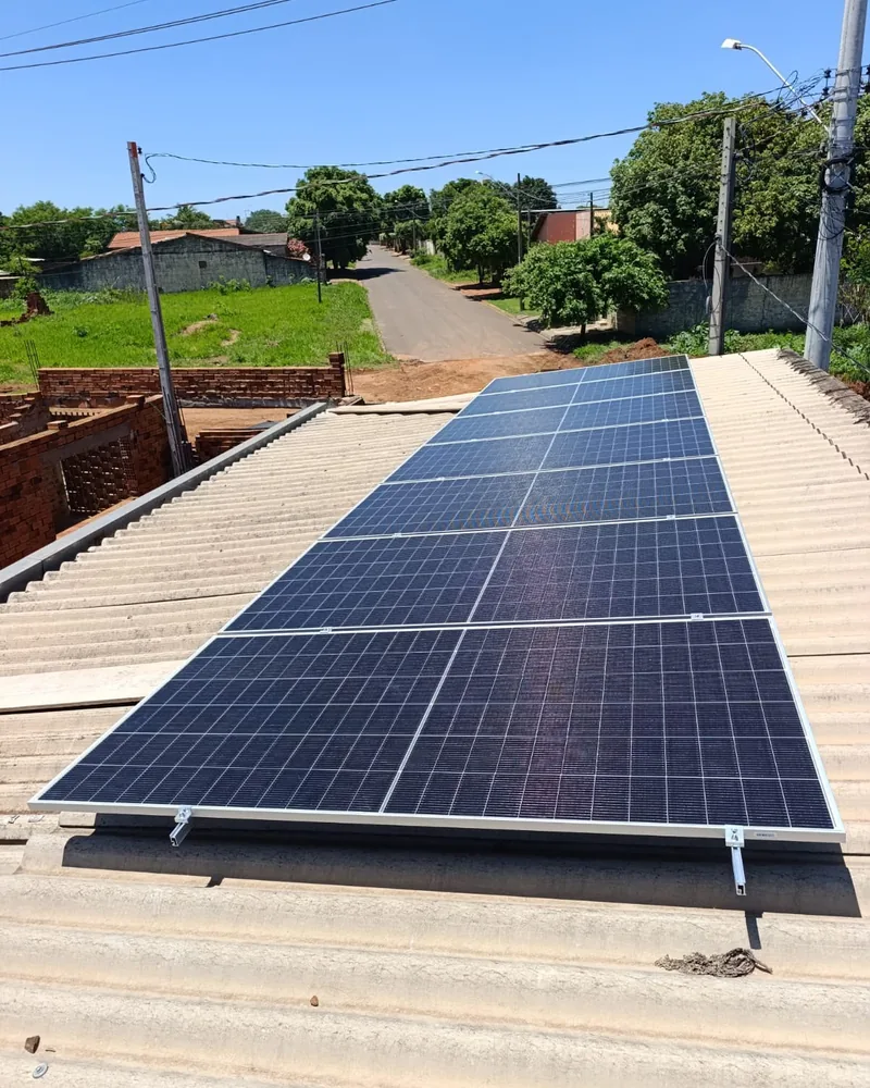 Painéis solares em telhado de fibrocimento, em rua residencial do interior