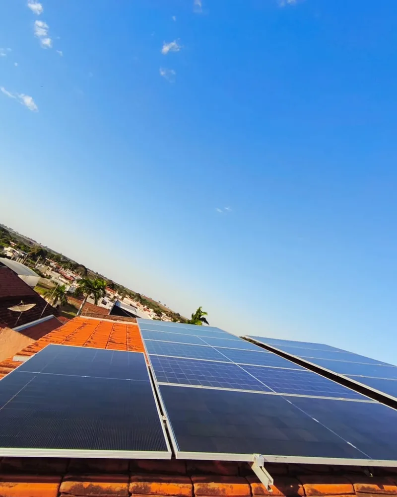 Painéis solares em telhado cerâmico sob céu azul limpo