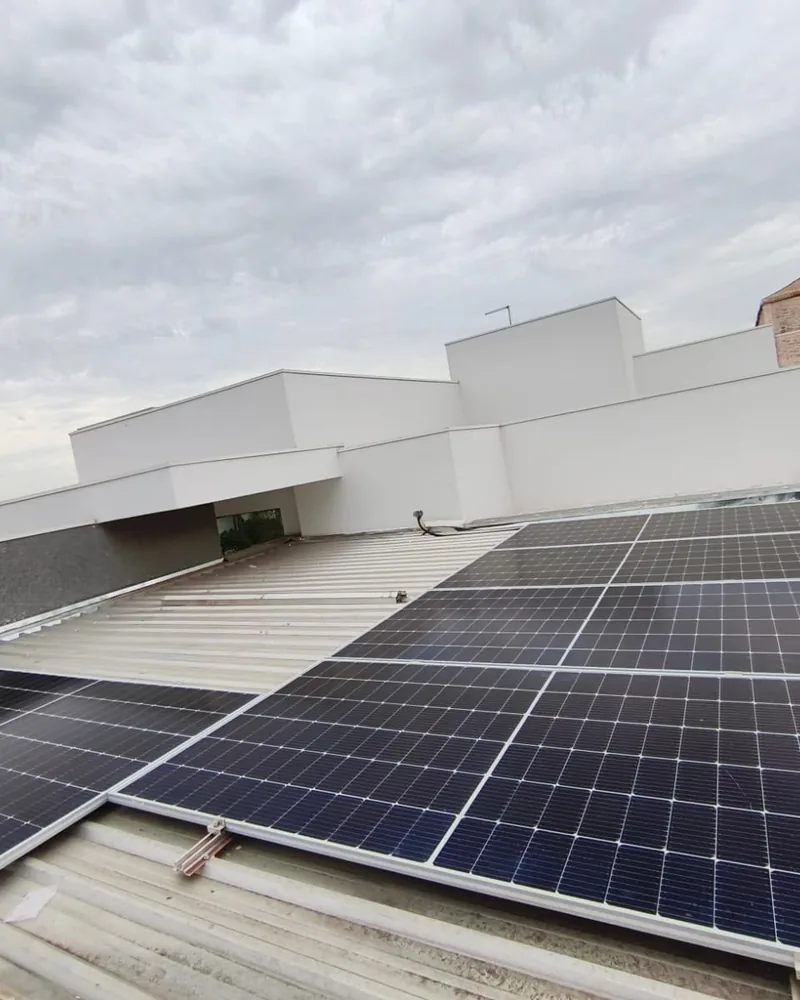 Painéis fotovoltaicos em laje branca, em dia nublado